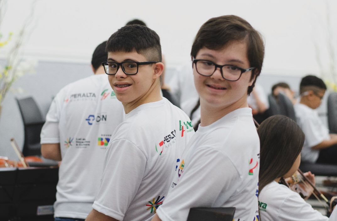 Alunos com deficiência sorrindo durante ensaio