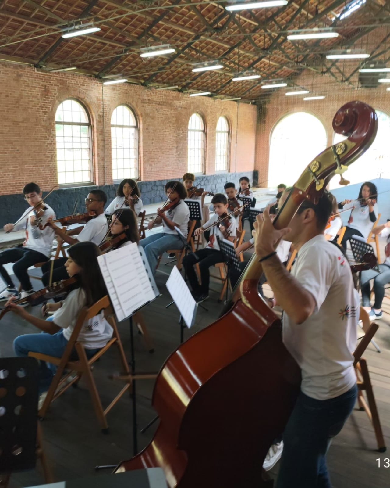 Orquestra durante ensaio em galpão histórico