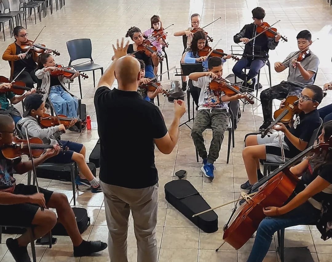 Maestro Douglas Leite regendo a Orquestra Mirim Na Trilha do Amanhã durante ensaio